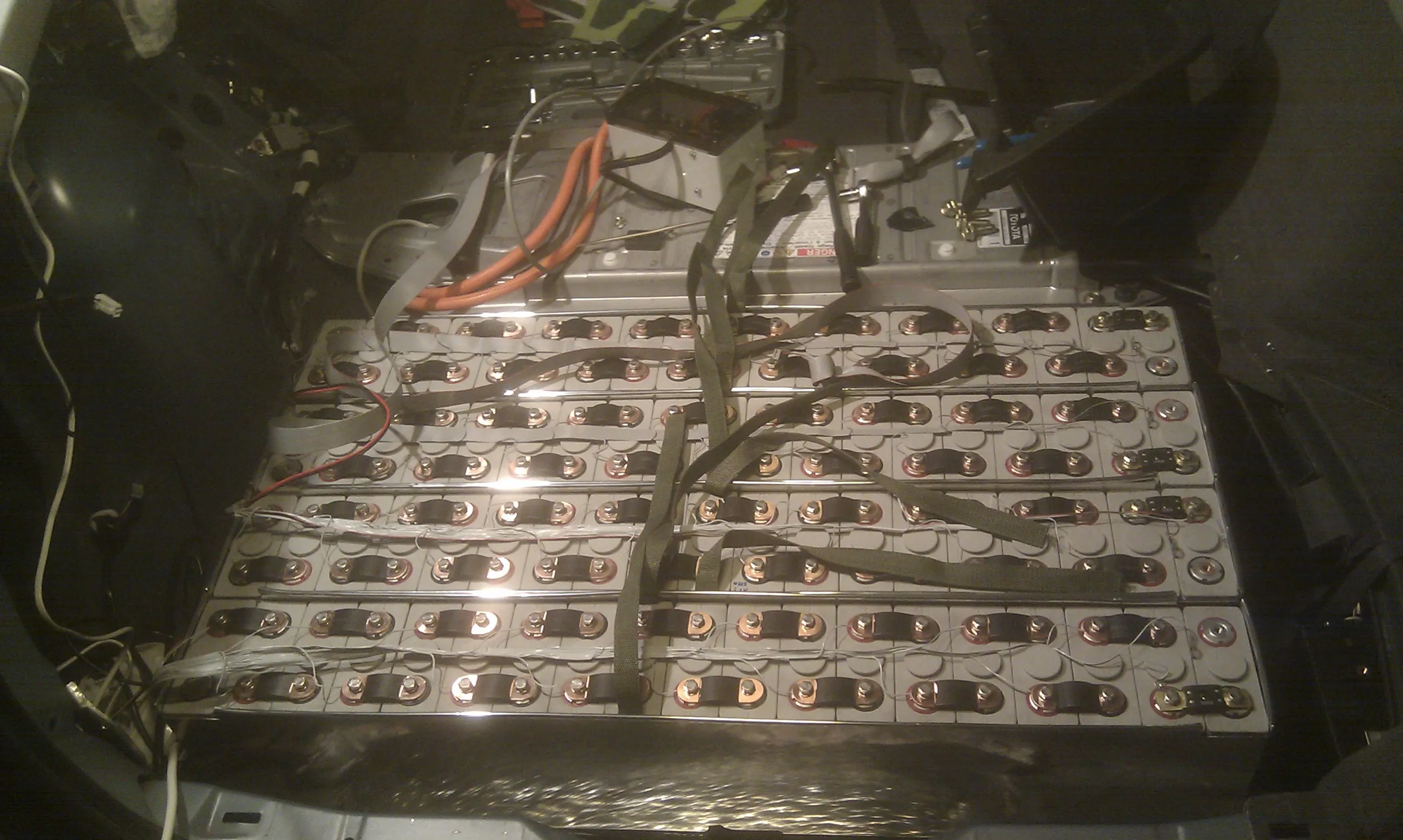76 LiFePo cells laid out in the Prius's boot, strapped down and wired into the monitoring loom