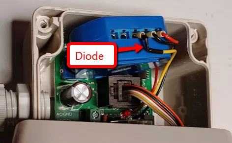 The sensor's enclosure opened up with a blue Shelly 1 fitted above its board, an arrow marking the added diode in the wiring