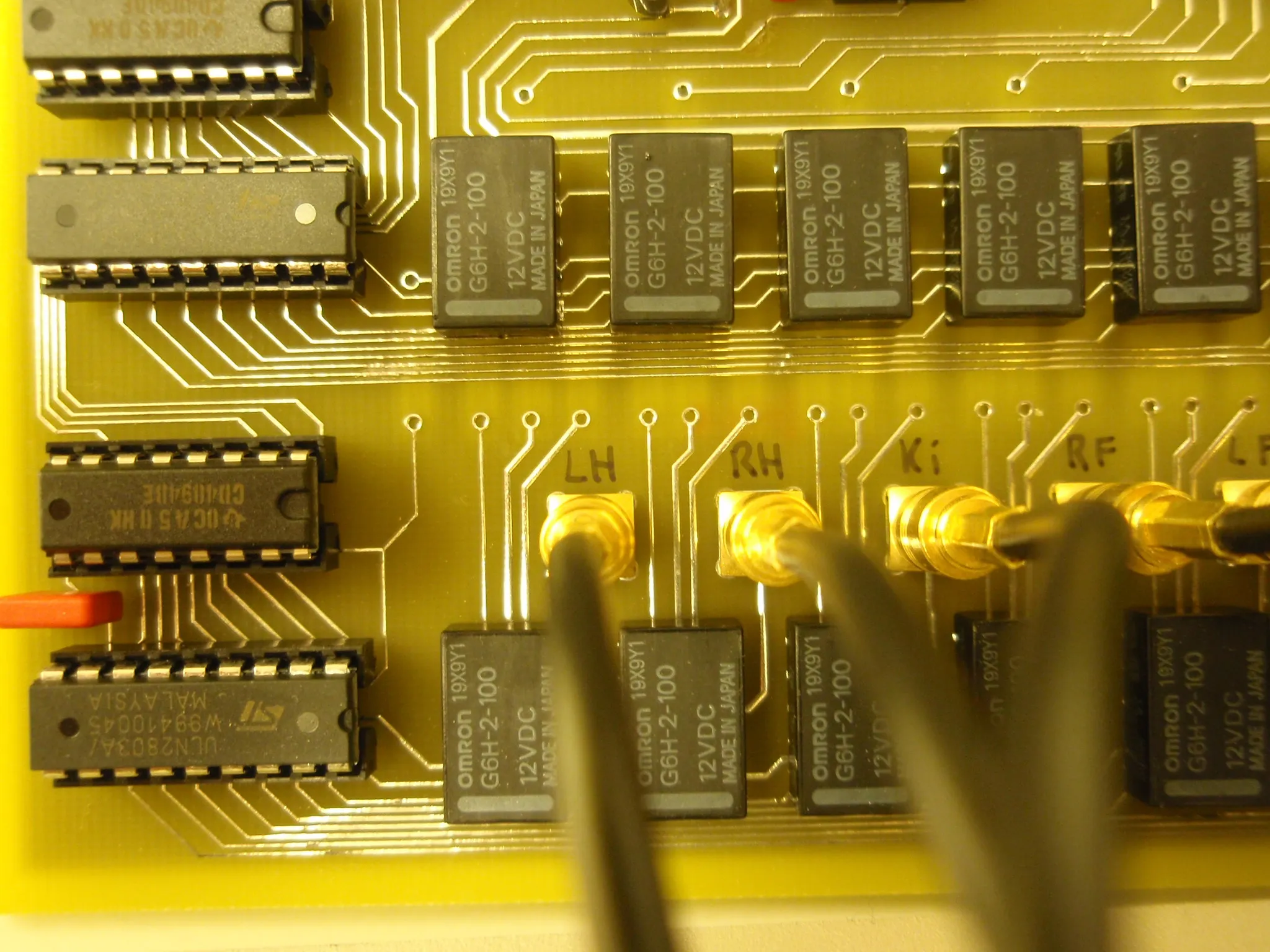 Close-up of the relay bank: Omron 12 V relays and CD4051 multiplexers driving jack sockets hand-labelled LH, RH, Ki, RF and LF